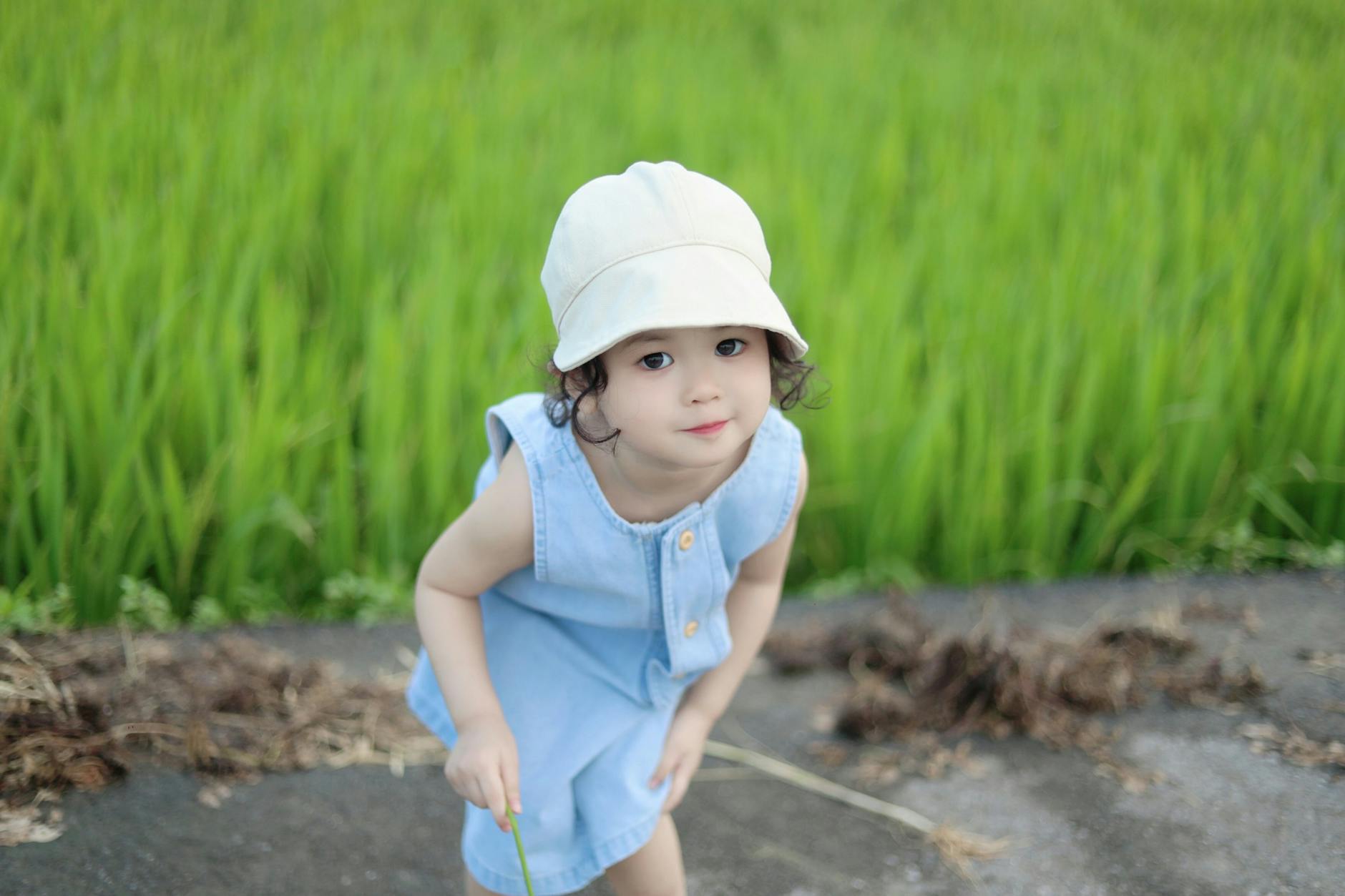 Adorable child in blue dress and hat enjoying a summer day outdoors. - toddler spring activities