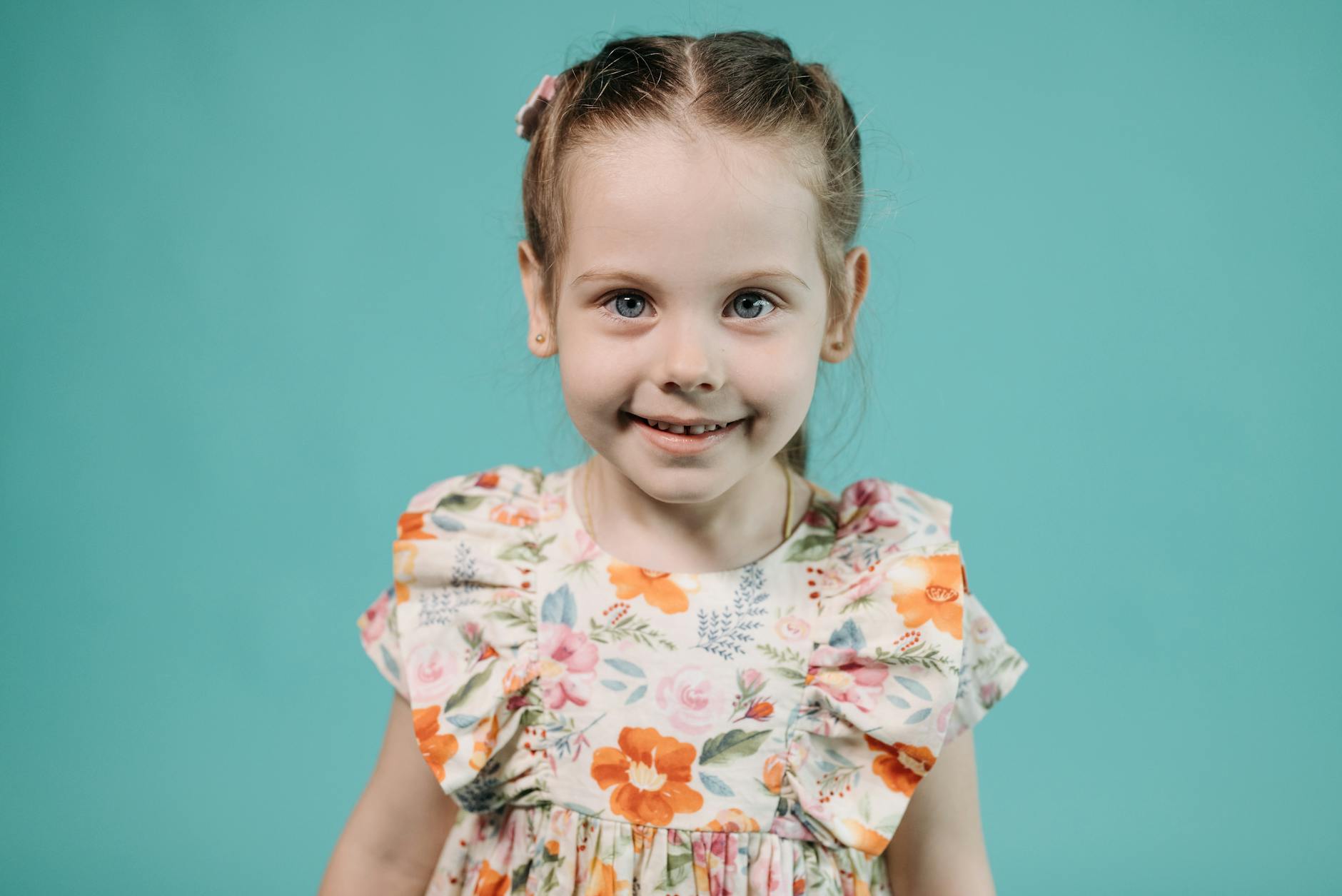 Adorable young girl smiling in a floral dress, studio portrait. - toddler spring tantrums