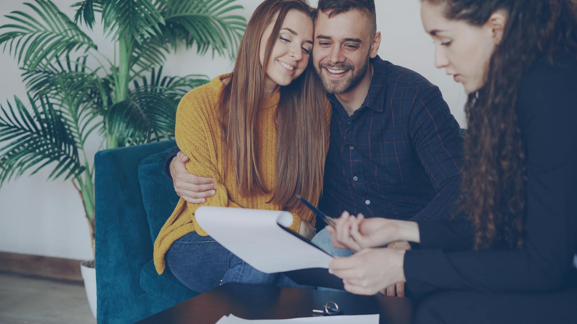 Smiling couple consulting with an adviser in a cozy office setting. - biblical marriage advice