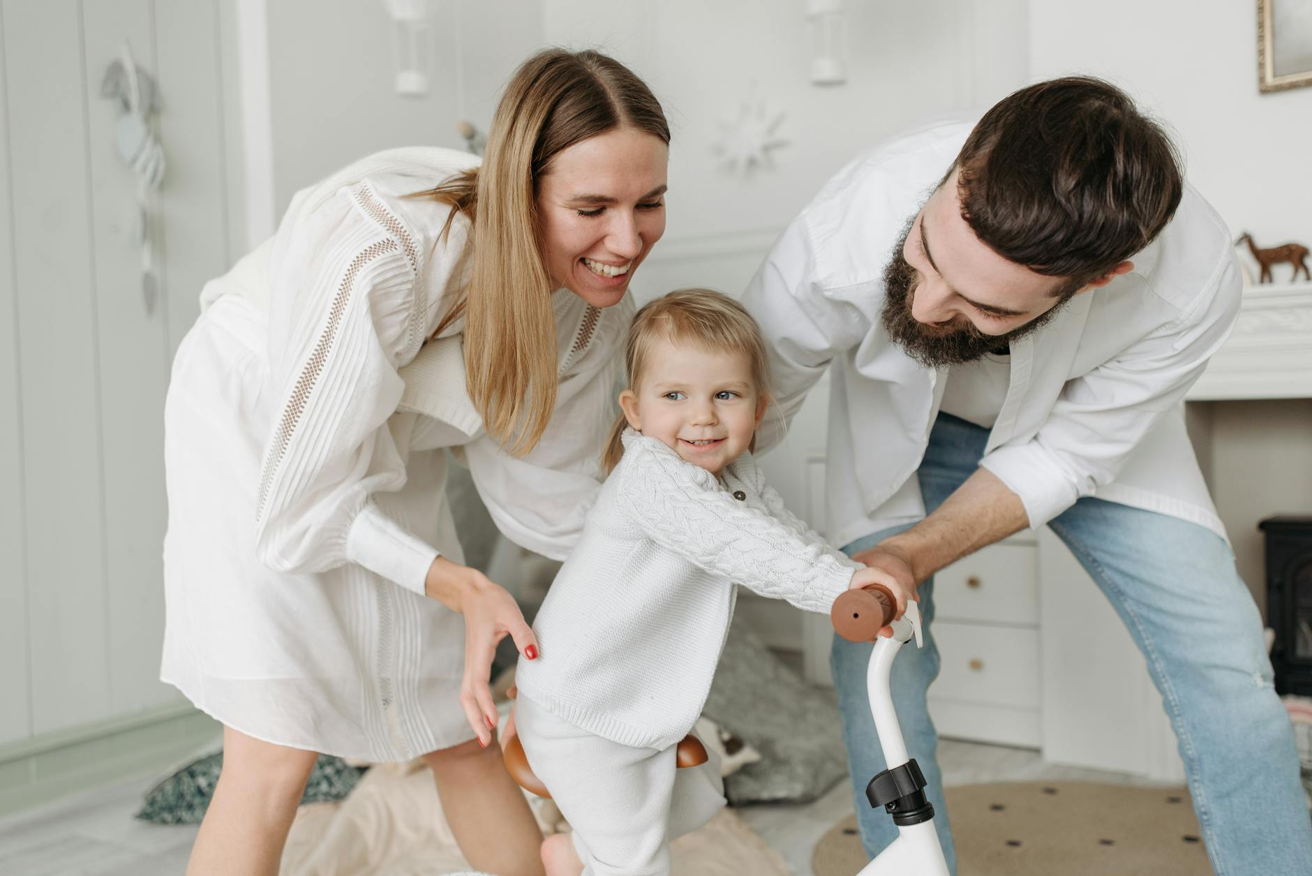 Loving parents playing with their cheerful daughter indoors, enjoying playtime together. - co-parenting after divorce