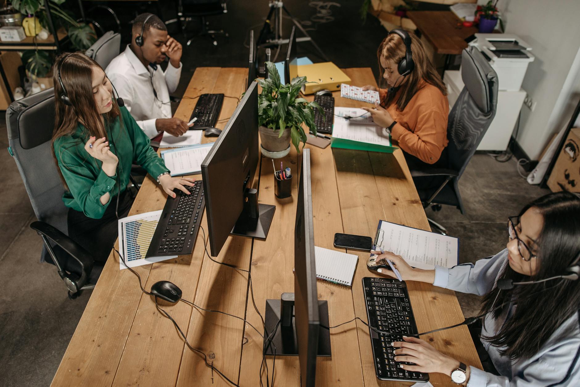 Diverse team of customer service representatives working collaboratively in a modern office environment. - communicate needs busy season