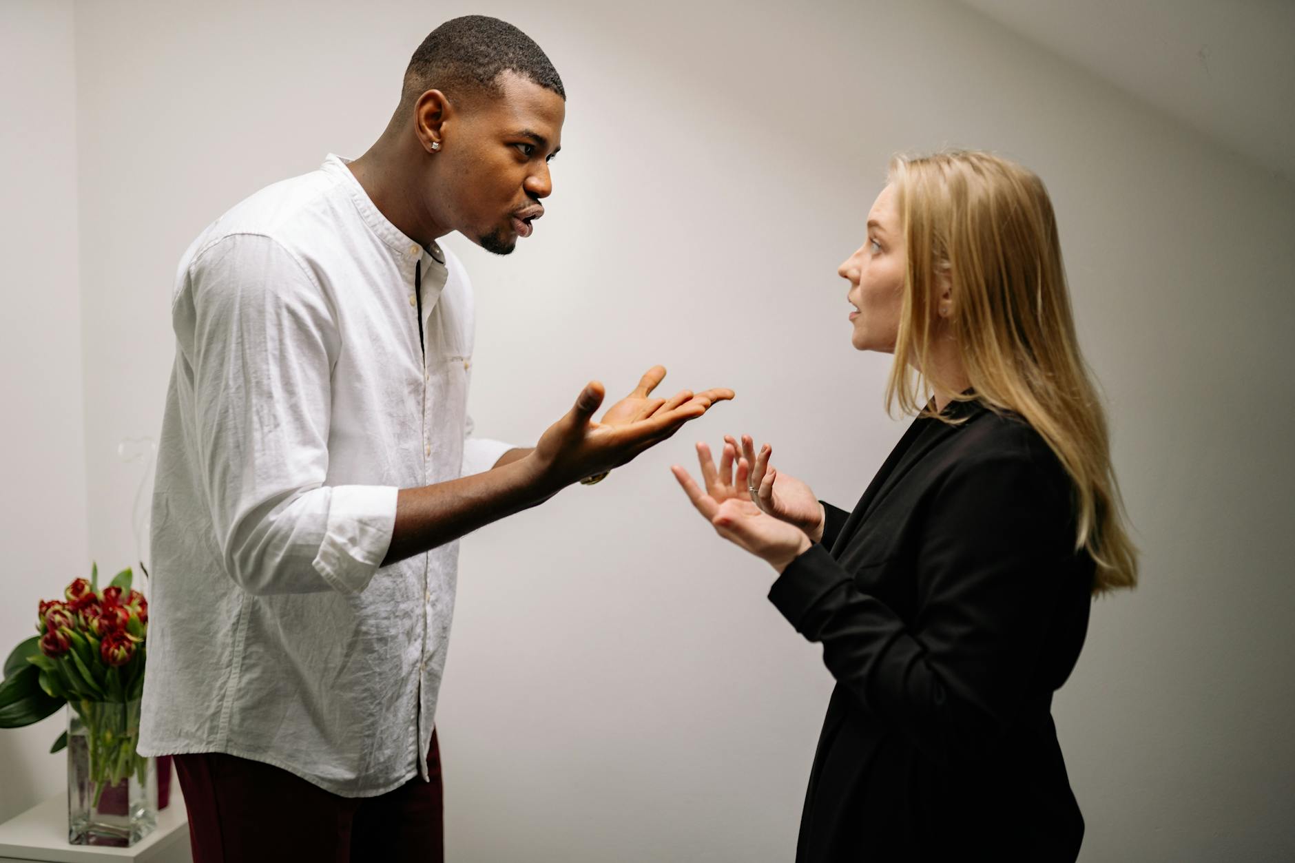 A man and woman engaged in a heated office argument, displaying emotion and intensity. - couple conflict resolution