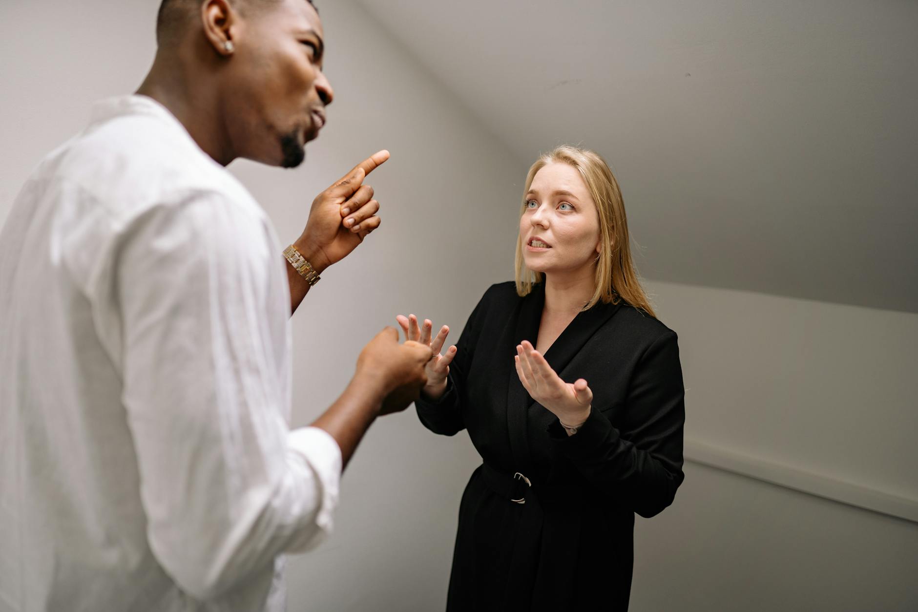 Two business professionals in a heated discussion inside a modern office space. - couple conflict resolution