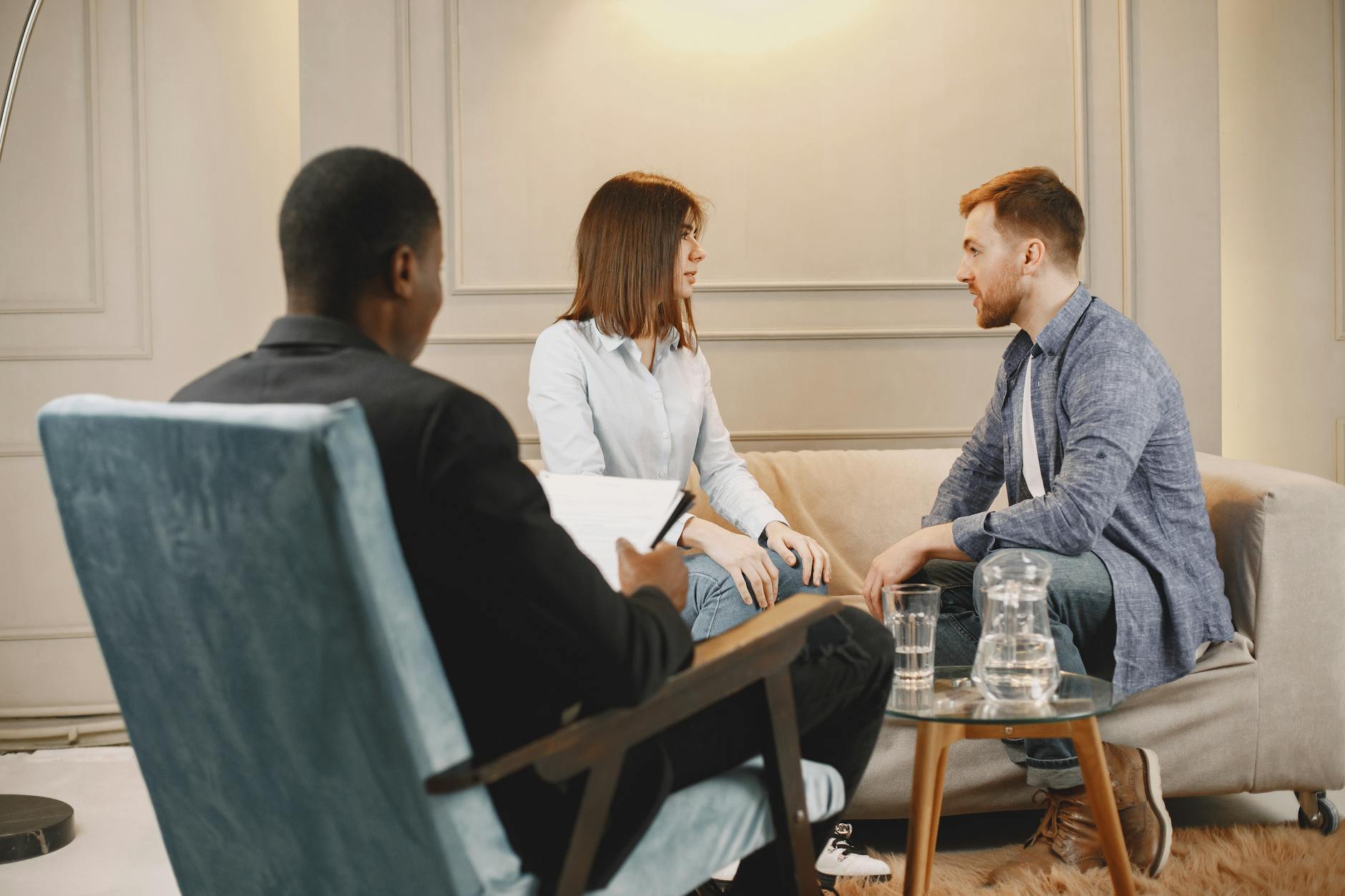 Couple in a counseling session with a therapist in a modern and cozy setting. - couples counseling benefits