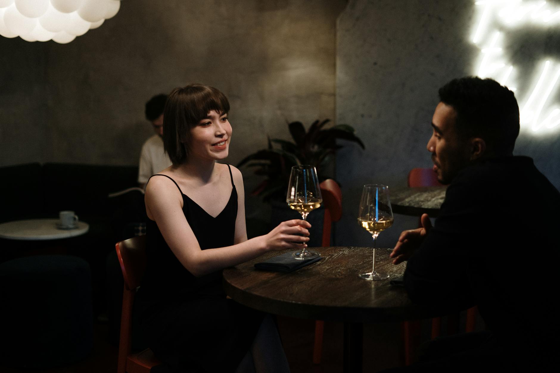 Couple enjoying a date night with white wine in a modern restaurant. - dating in 30s