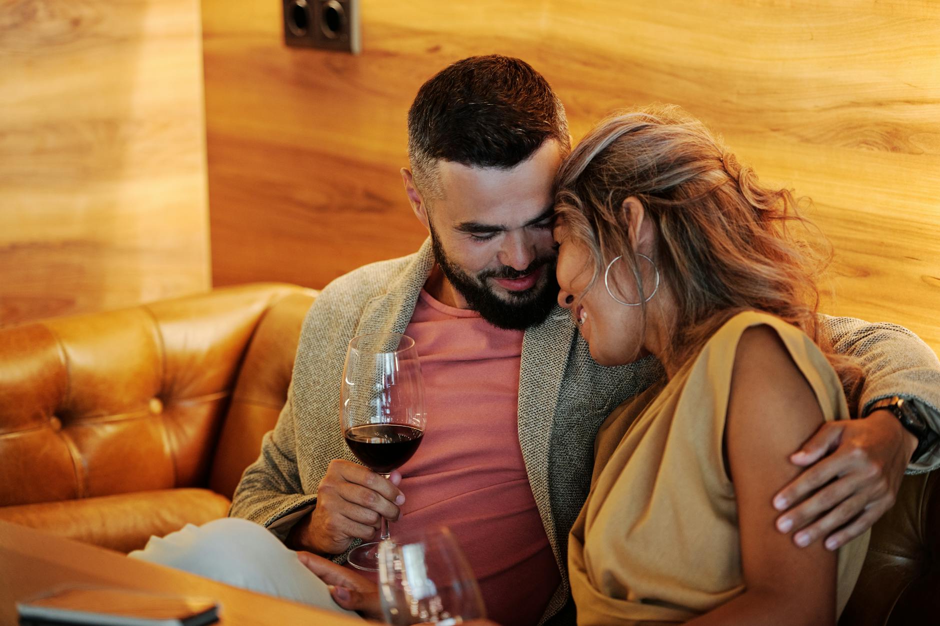 Loving couple embracing with wine glasses. Perfect cozy moment indoors. - dating in 40s