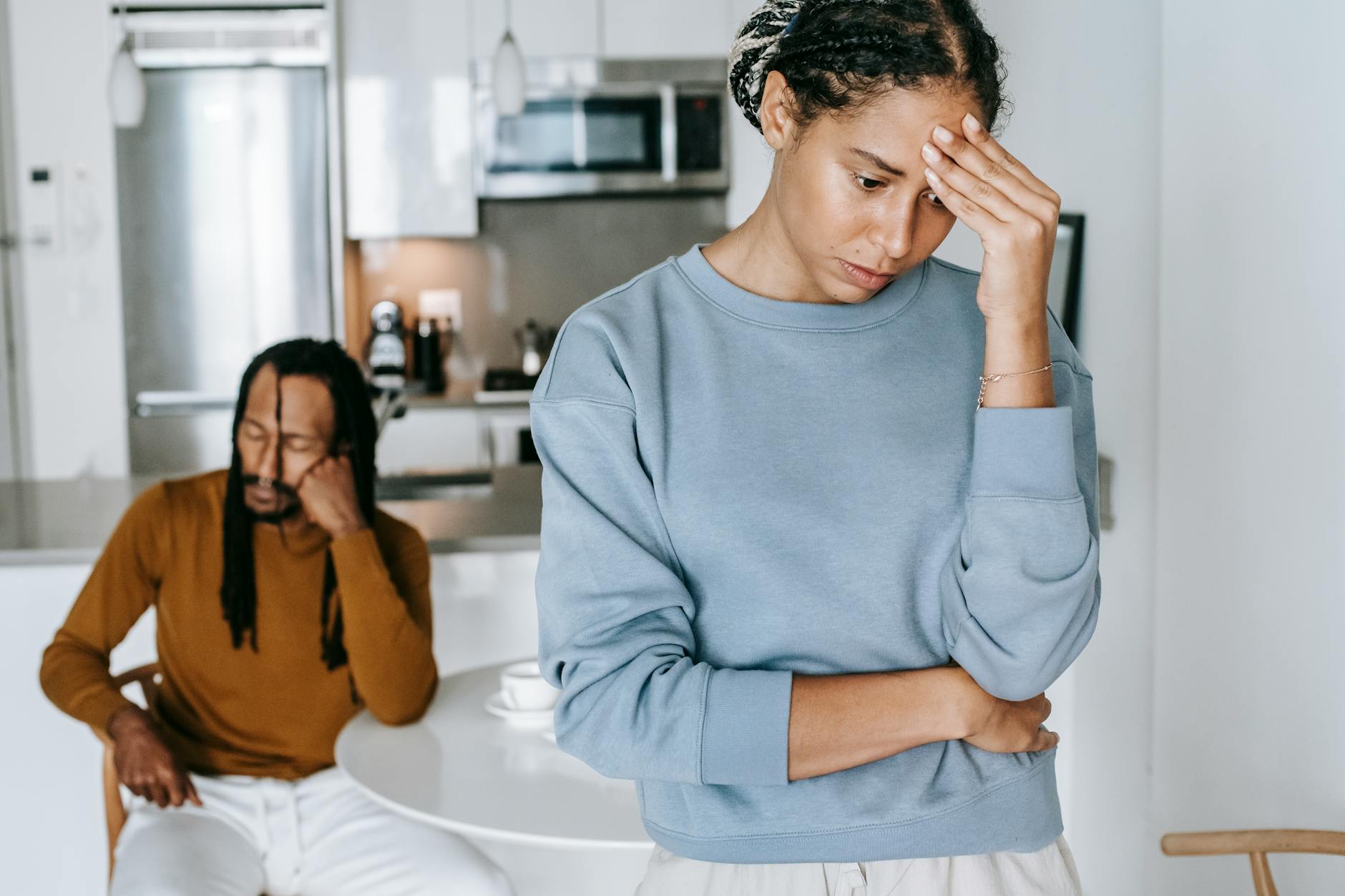Young African American guy sitting at table and having conflict with lady at home - declutter relationship conflict
