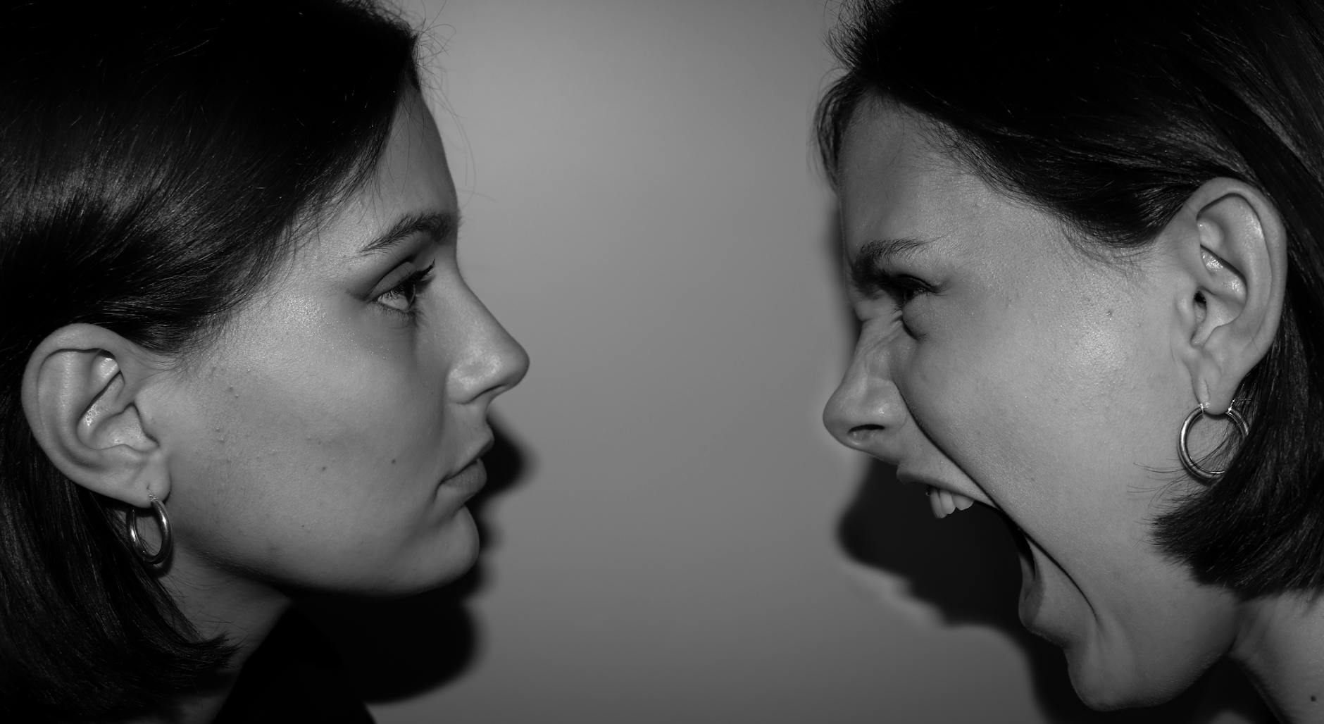 Two women face each other in high contrast, one shouting, depicting raw emotion. - free anger management