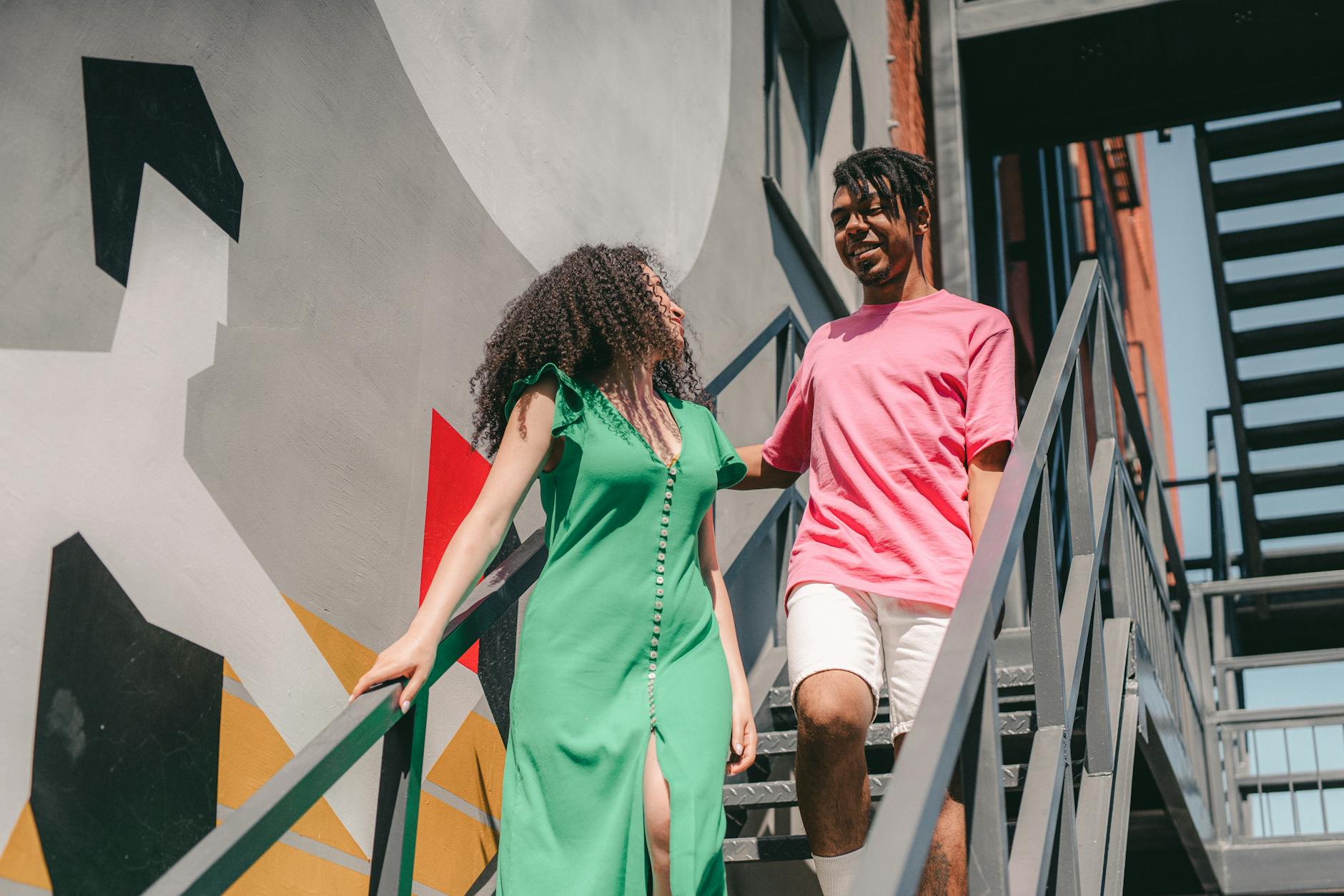 Happy couple walking down stairs, showcasing love and modern style. - green flags relationship