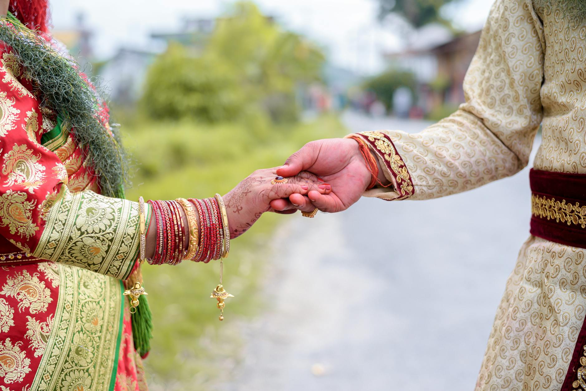 A couple holding hands in traditional Indian attire, symbolizing love and unity. - marriage traditions