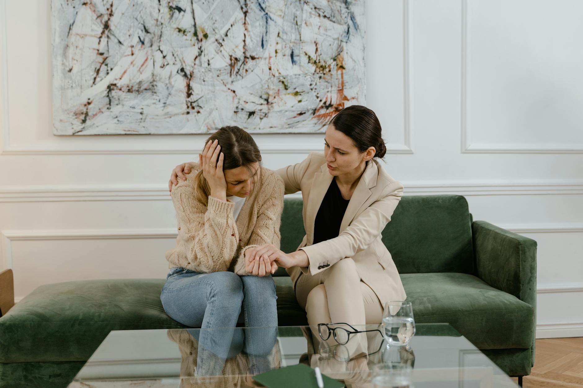A therapy session where a concerned therapist supports a distressed woman in a modern office. - overthinking therapy