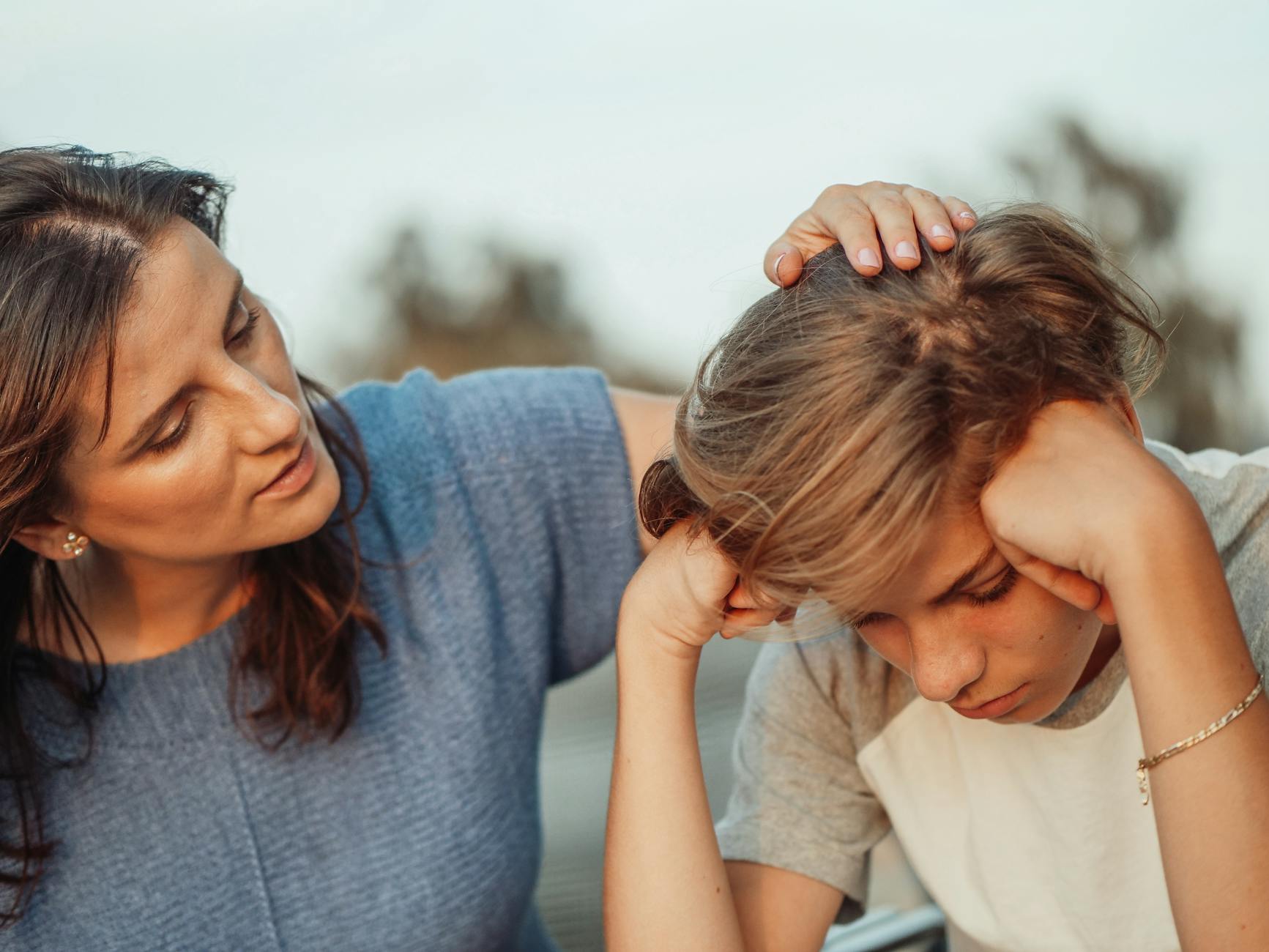A mother offers support to her discouraged teenager son, portraying love and understanding. - parent stress relief
