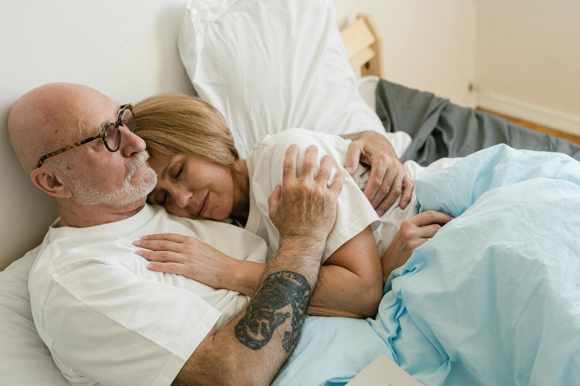 Senior couple embracing in bed, showcasing love and togetherness. - rebuild marriage intimacy