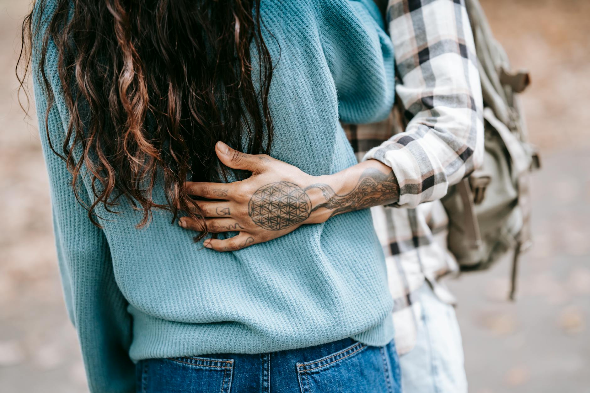 Crop anonymous couple standing close while spending autumn day together and embracing in park - reconnect with partner
