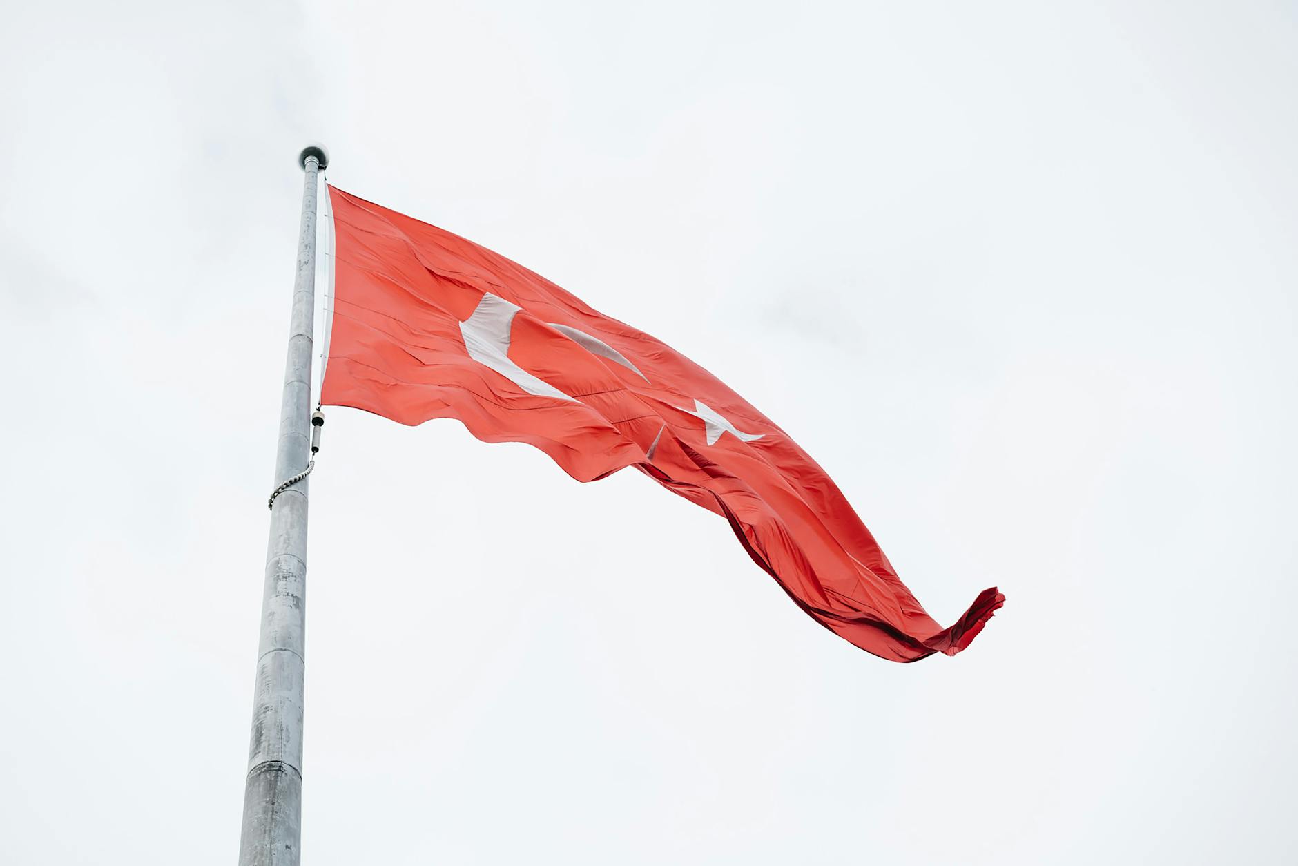 A vibrant Turkish flag waves against the sky, representing national pride in Istanbul, Turkey. - red flags relationships