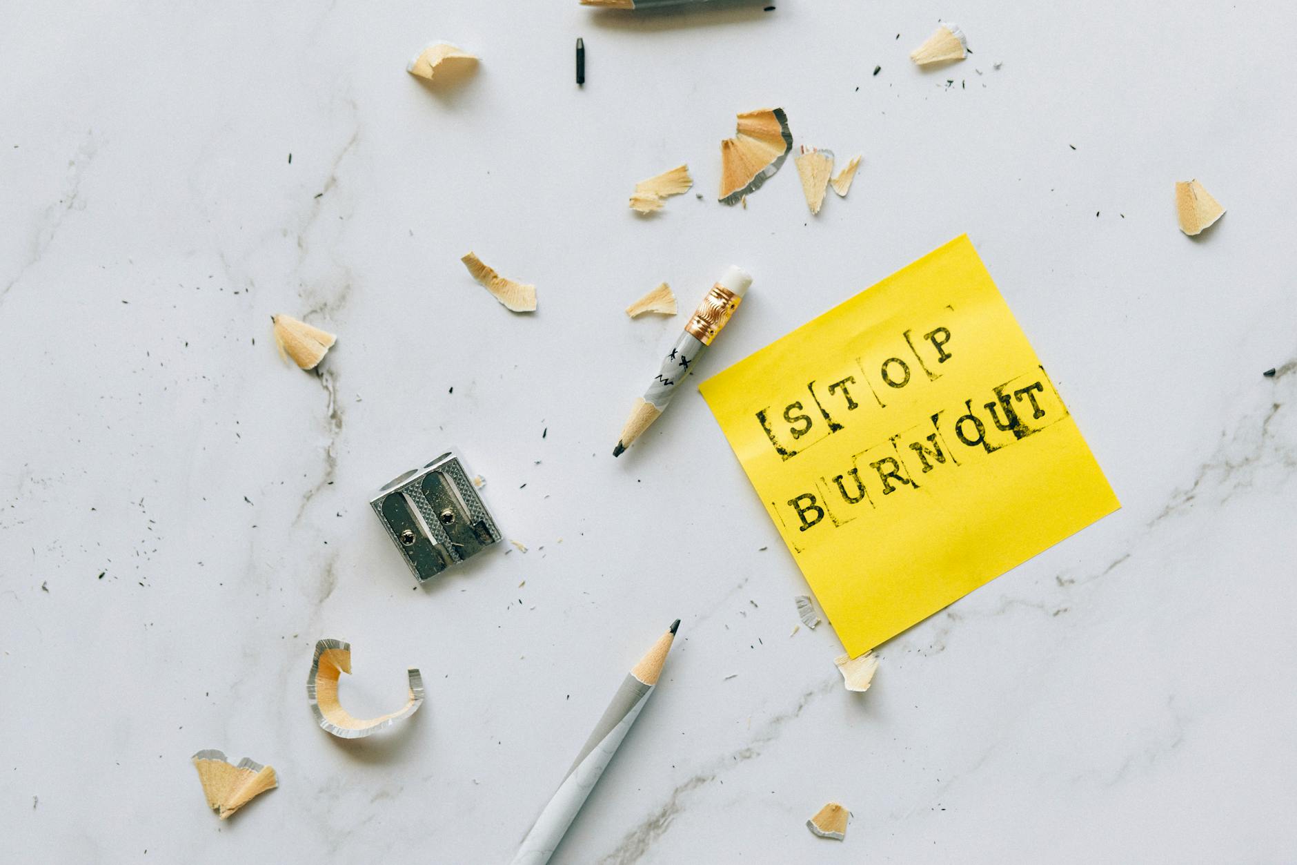 Pencil and shavings with 'Stop Burnout' note on marble surface convey stress relief concept. - spring burnout recovery