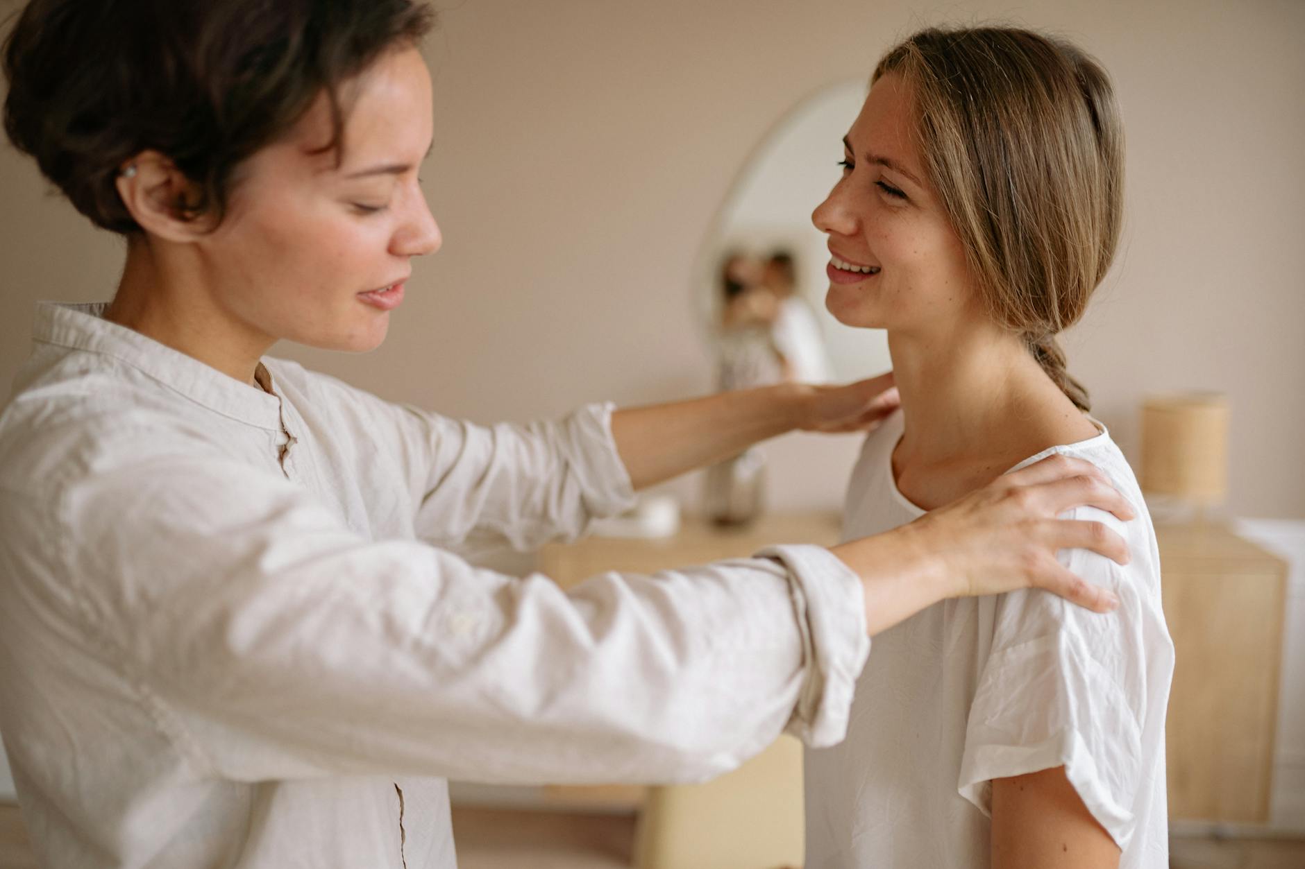 Two women engage in a calming massage therapy session in an indoor setting, promoting wellness. - therapist for spring change