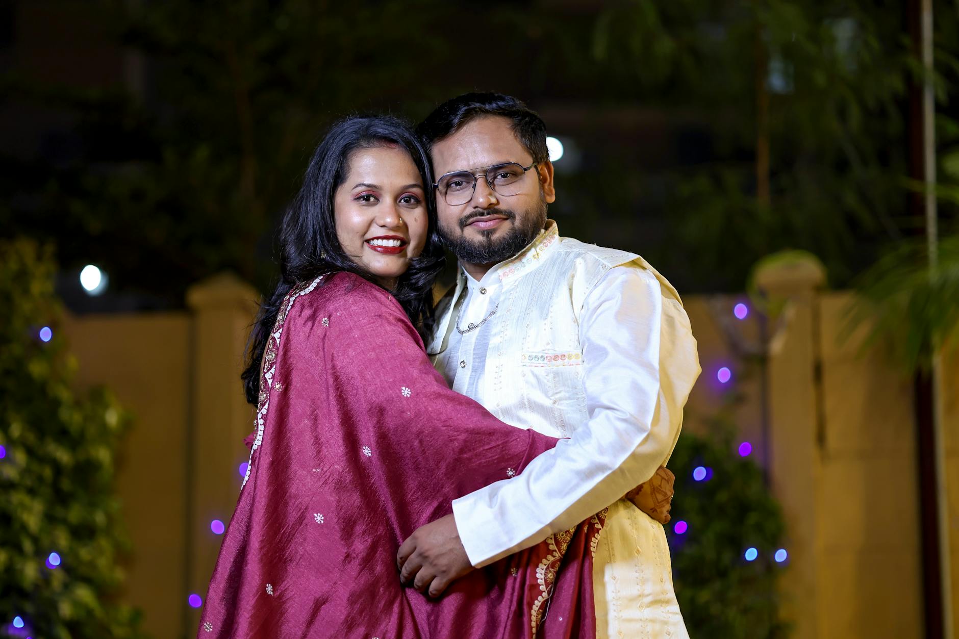 A joyful couple embracing outdoors at night, illuminated with festive lights. - deep couple communication