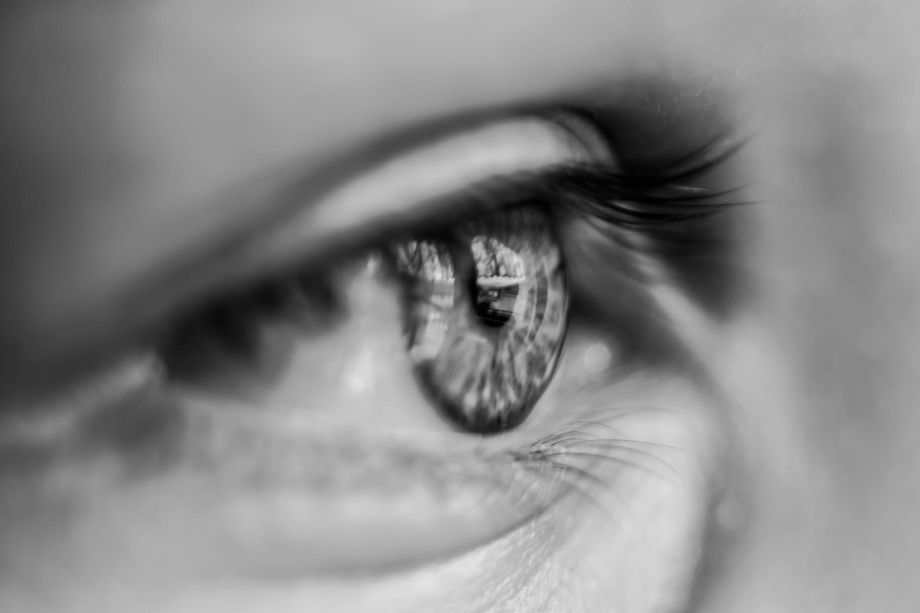 Artistic close-up of a human eye in monochrome, showcasing detail and reflection. - emotional organization