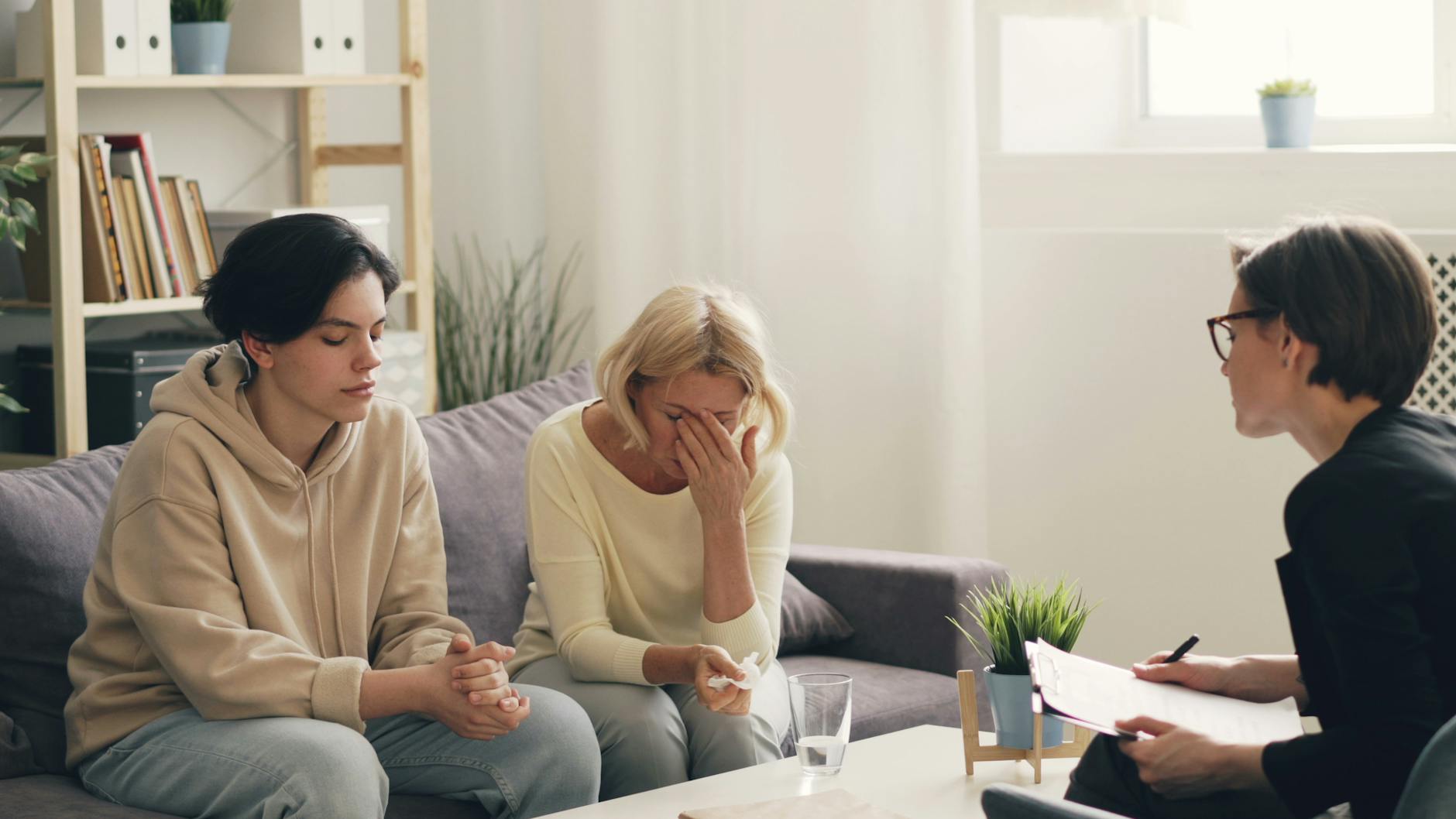 Emotional family therapy session with a therapist indoors, conveying connection and support. - family communication empathy