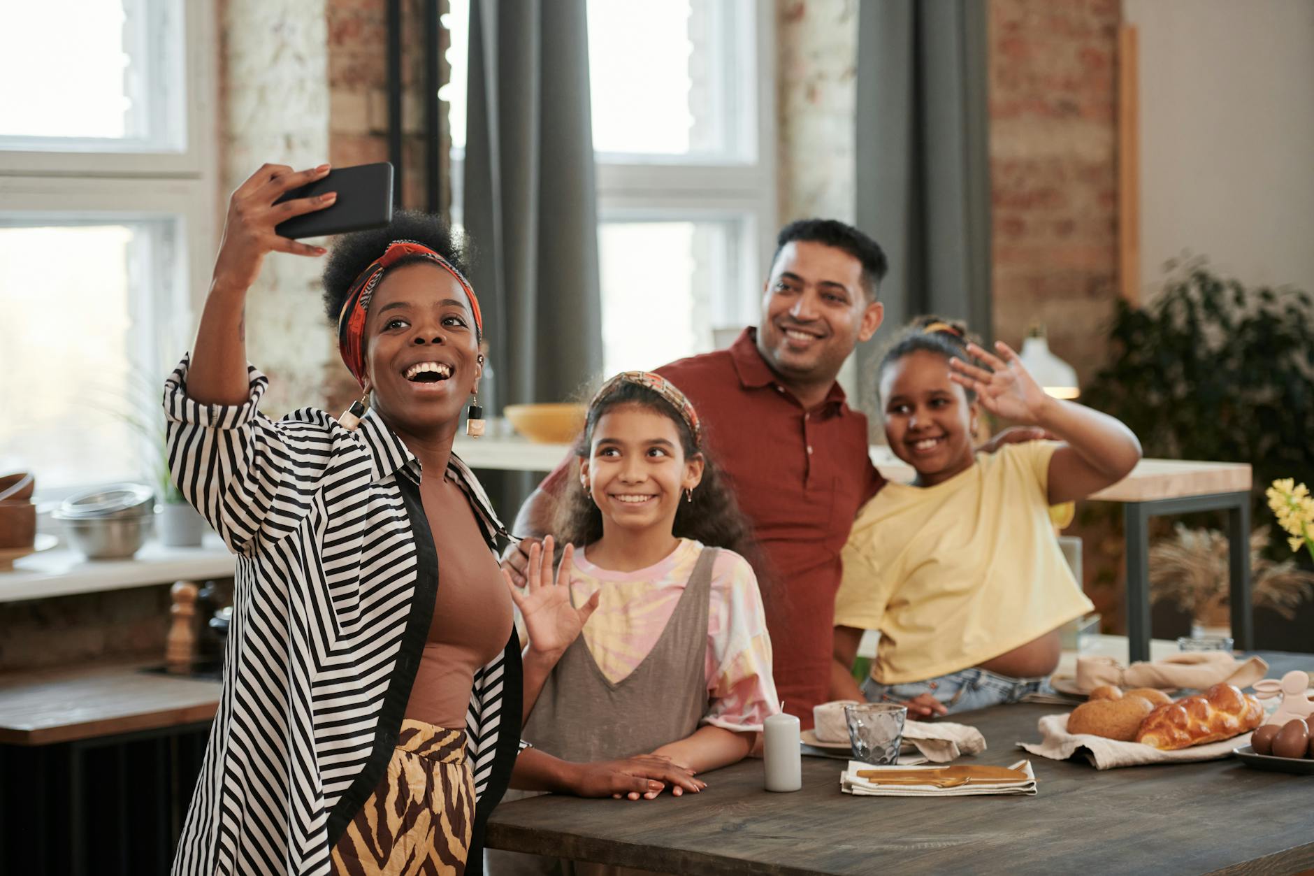 A joyful family captures a group selfie in a cozy kitchen setting, smiling together. - family communication tips
