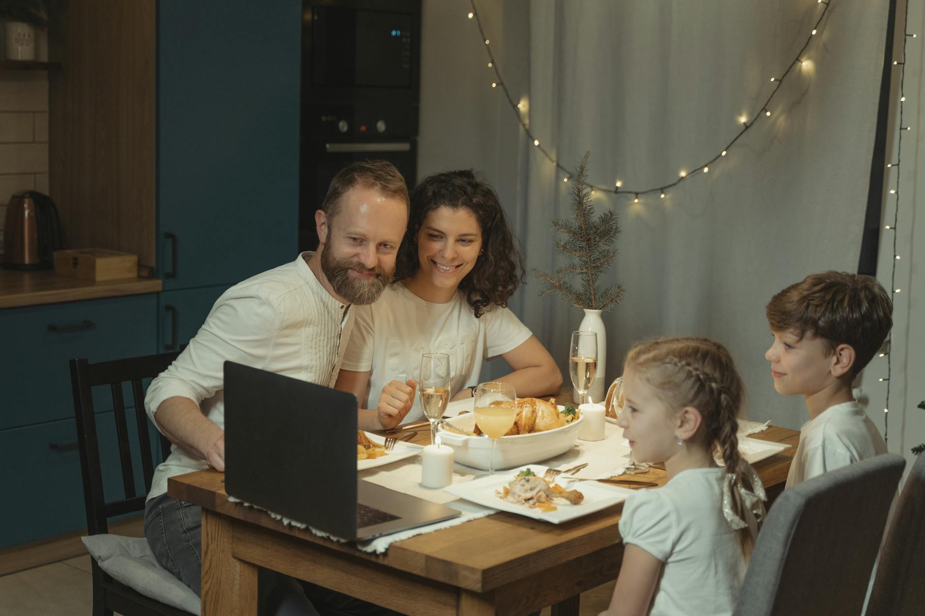 Family enjoying a Christmas dinner with online video call, sharing holiday joy indoors. - family communication tips