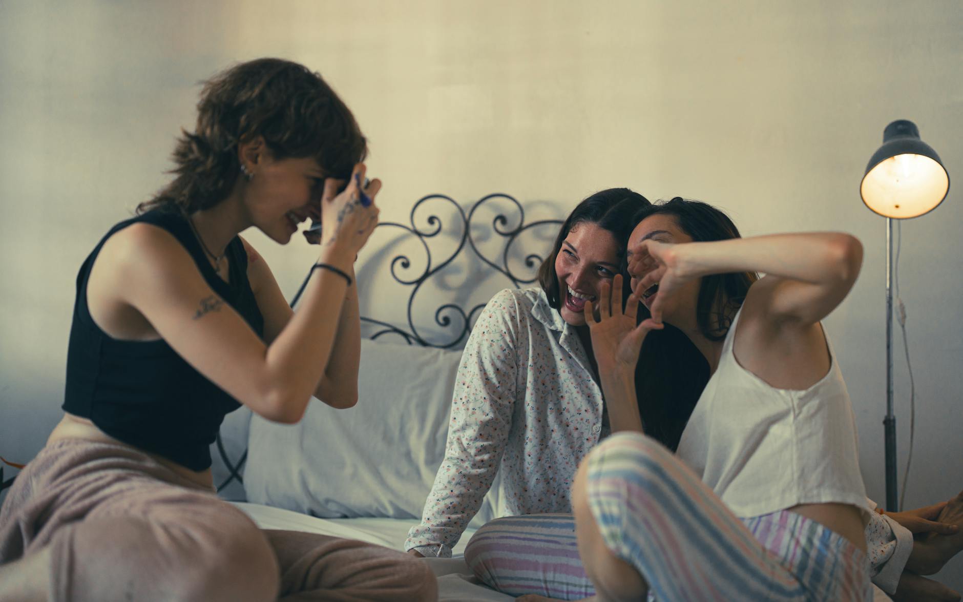 Three young women having fun at a cozy sleepover, capturing joyful moments. - friends to lovers