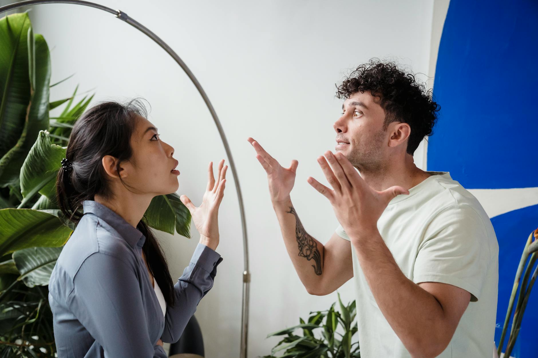 A couple argues indoors amidst greenery, showcasing emotions and interpersonal conflict. - improve relationship communication