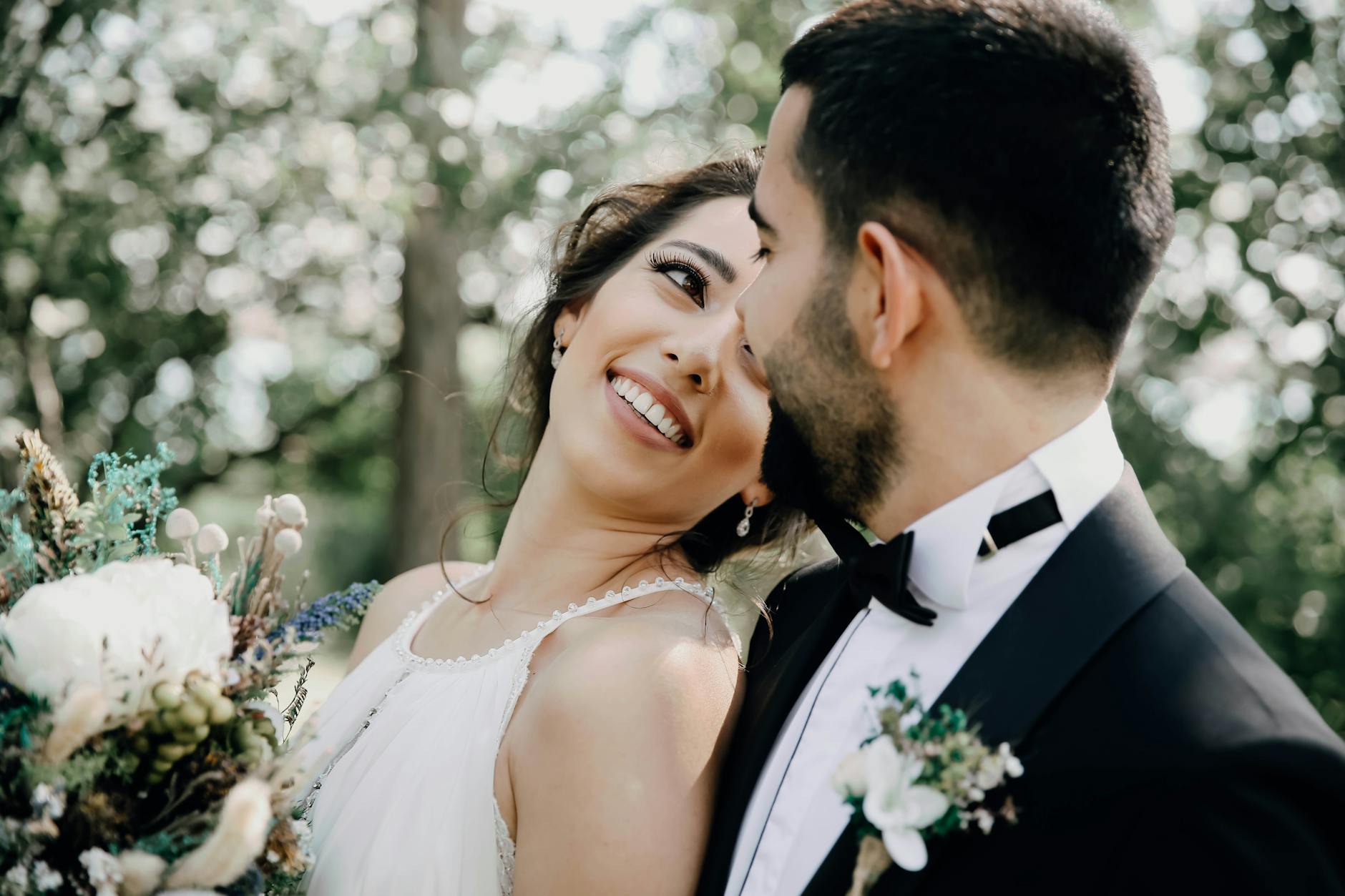 A joyful bride and groom share a loving moment in an outdoor setting, captured beautifully. - post wedding connection