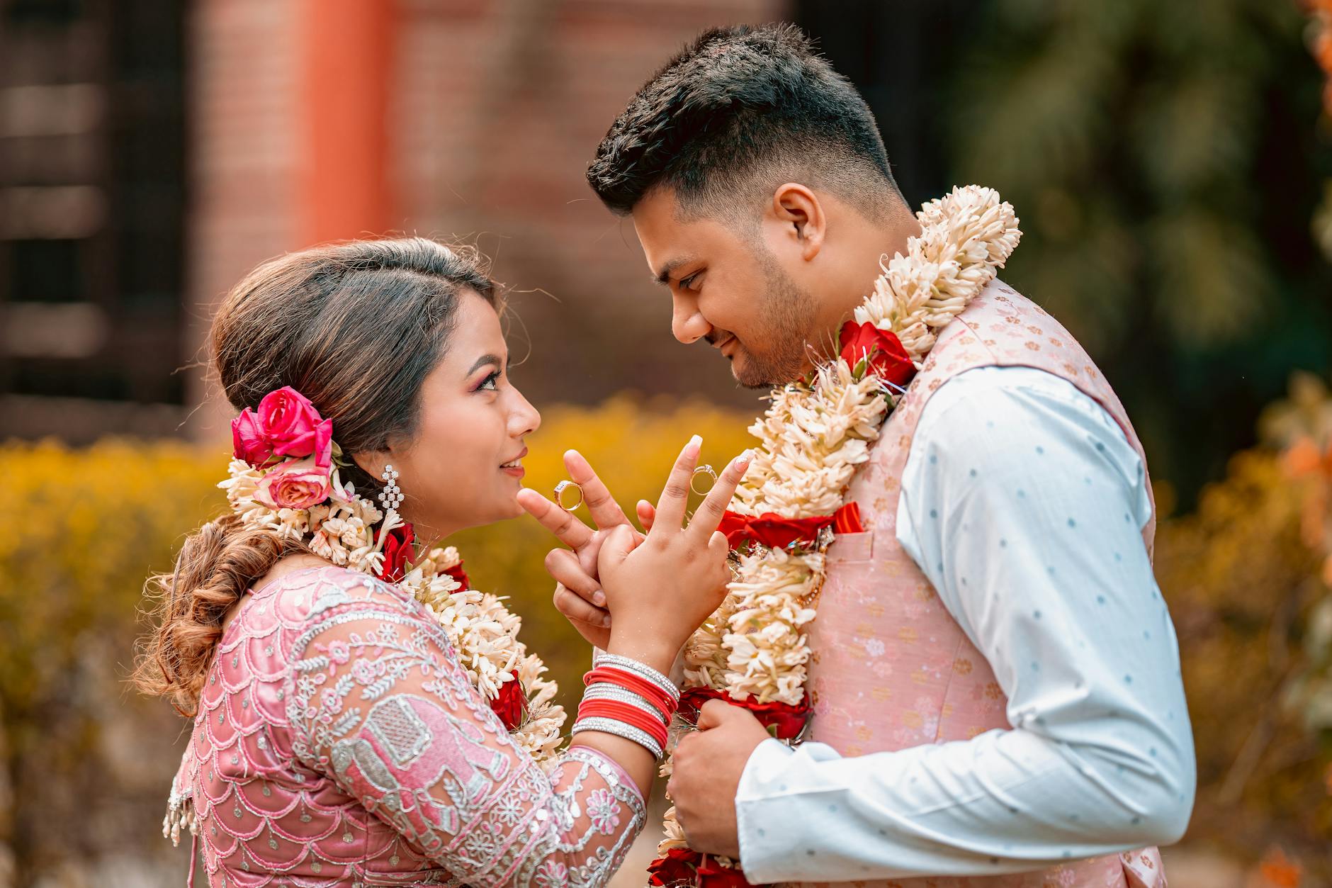 A couple in traditional Indian wedding attire beautifully decorated with floral garlands and love. - post wedding connection