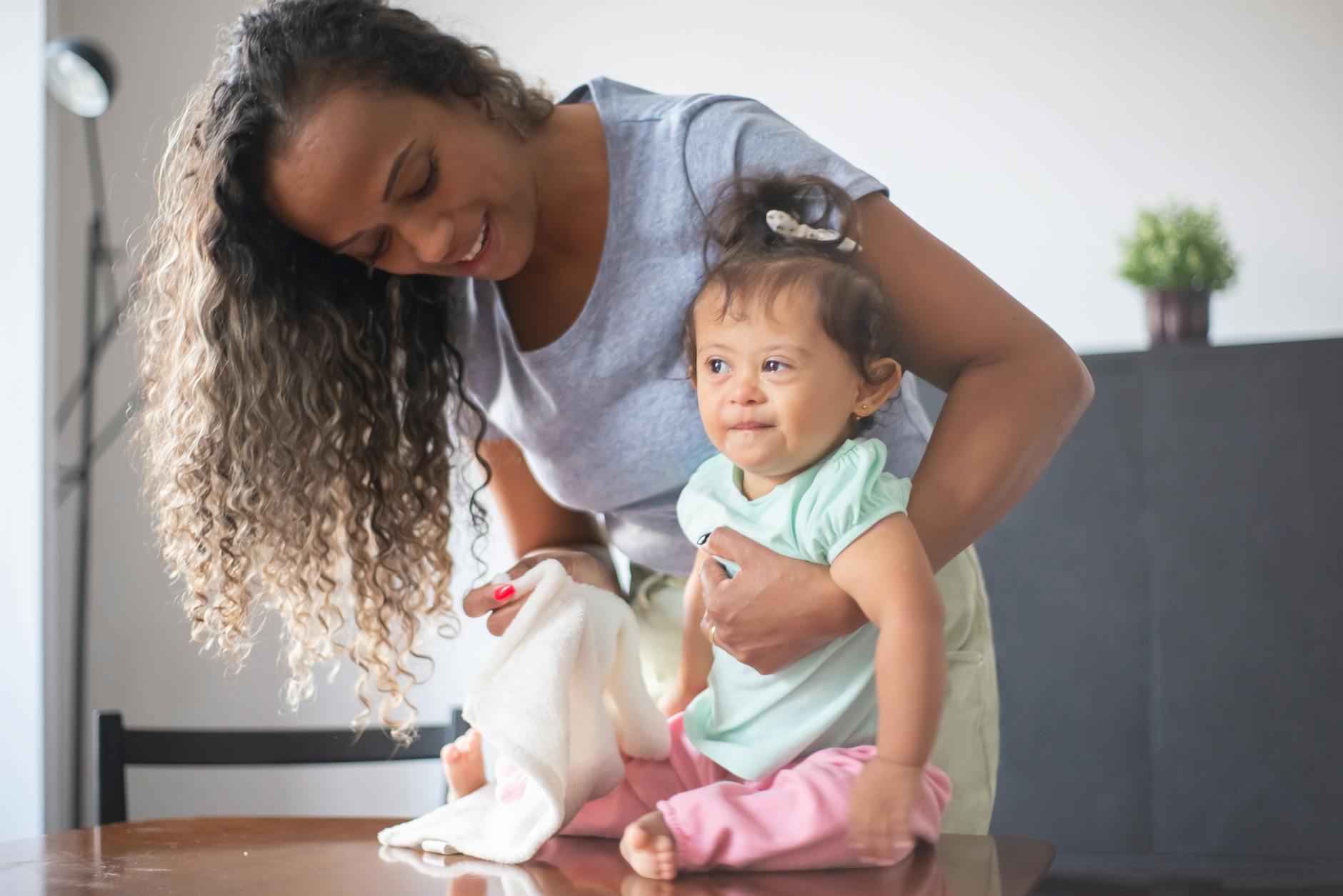 A happy mother and baby bonding in a cozy indoor setting, highlighting family love and care. - toddler self care